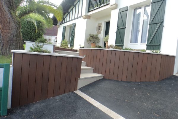 Aménagement d'un jardin fleuri sur Saint-Jean-de-Luz avec entrée, massifs fleuris et piscine.