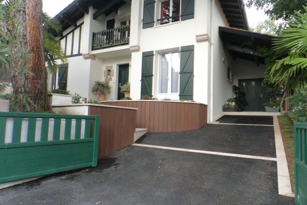Aménagement d'un jardin fleuri sur Saint-Jean-de-Luz avec entrée, massifs fleuris et piscine.