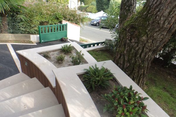 Aménagement d'un jardin fleuri sur Saint-Jean-de-Luz avec entrée, massifs fleuris et piscine.